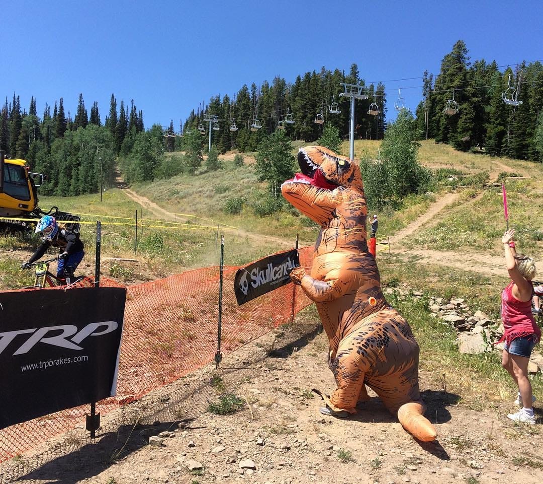 Racer crossing the finish line in a T-rex costume