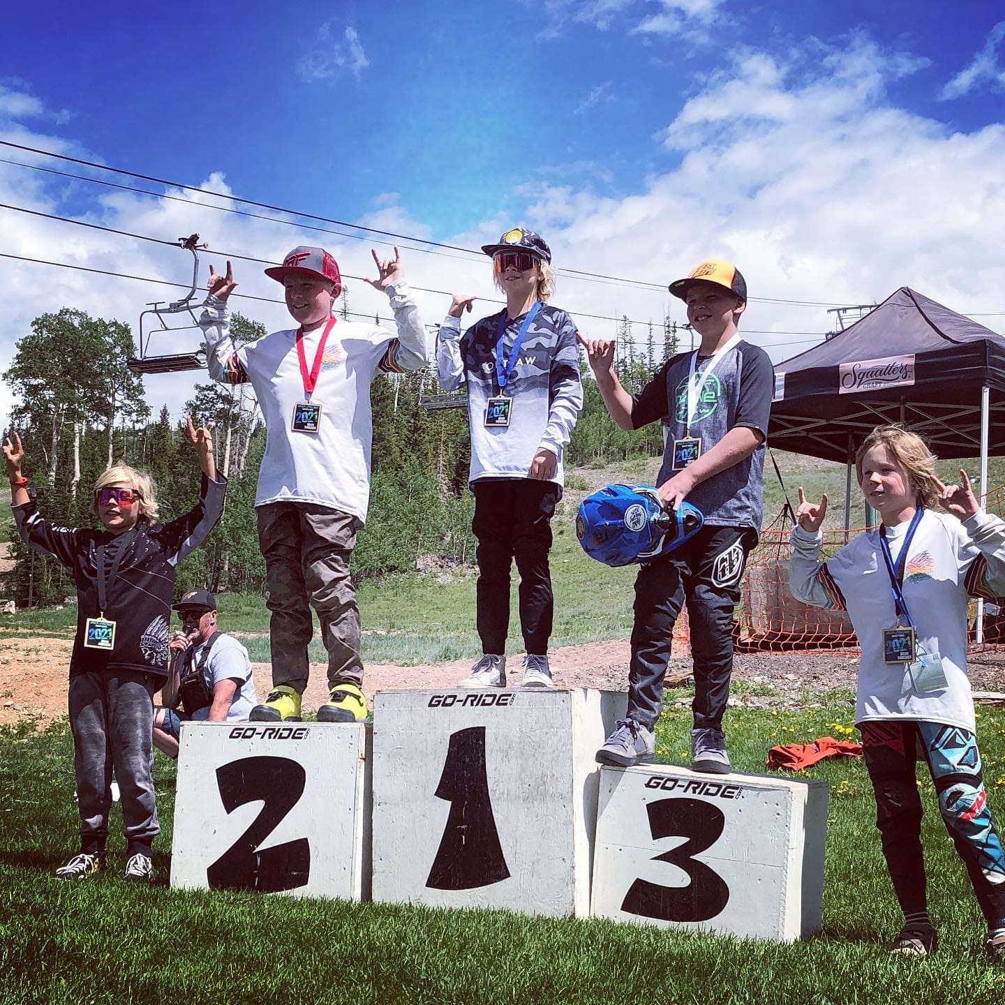 Young racers throwing peace signs on the youth podium